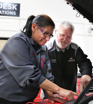 student and instructor working on an automobile
