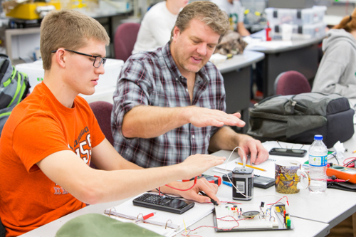 Electronics student with instructor working on a project