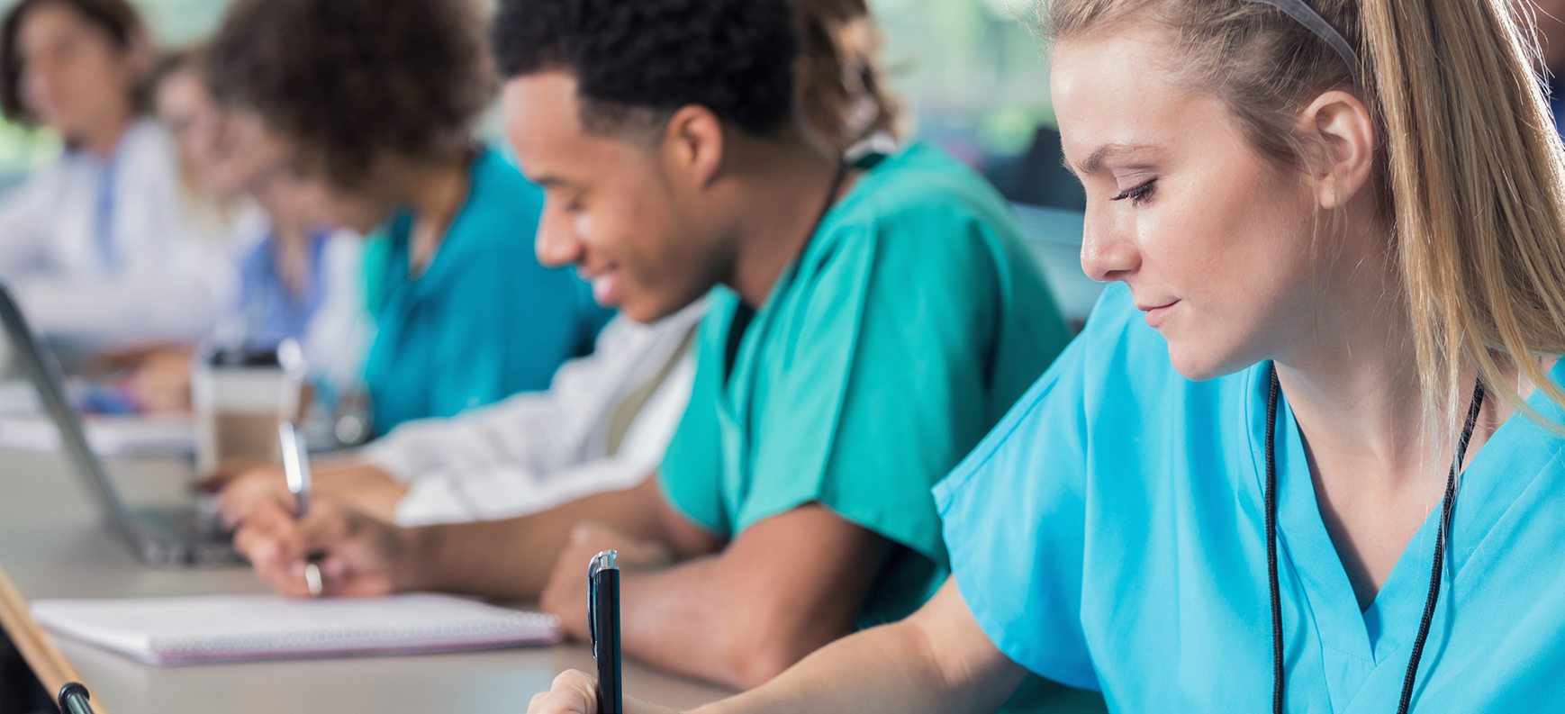 Nursing students taking notes in classroom