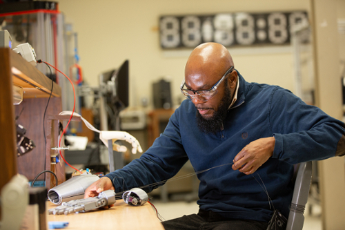 Robotics student working on mechanized arm 