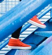 person with red tennis shoes walking up steps