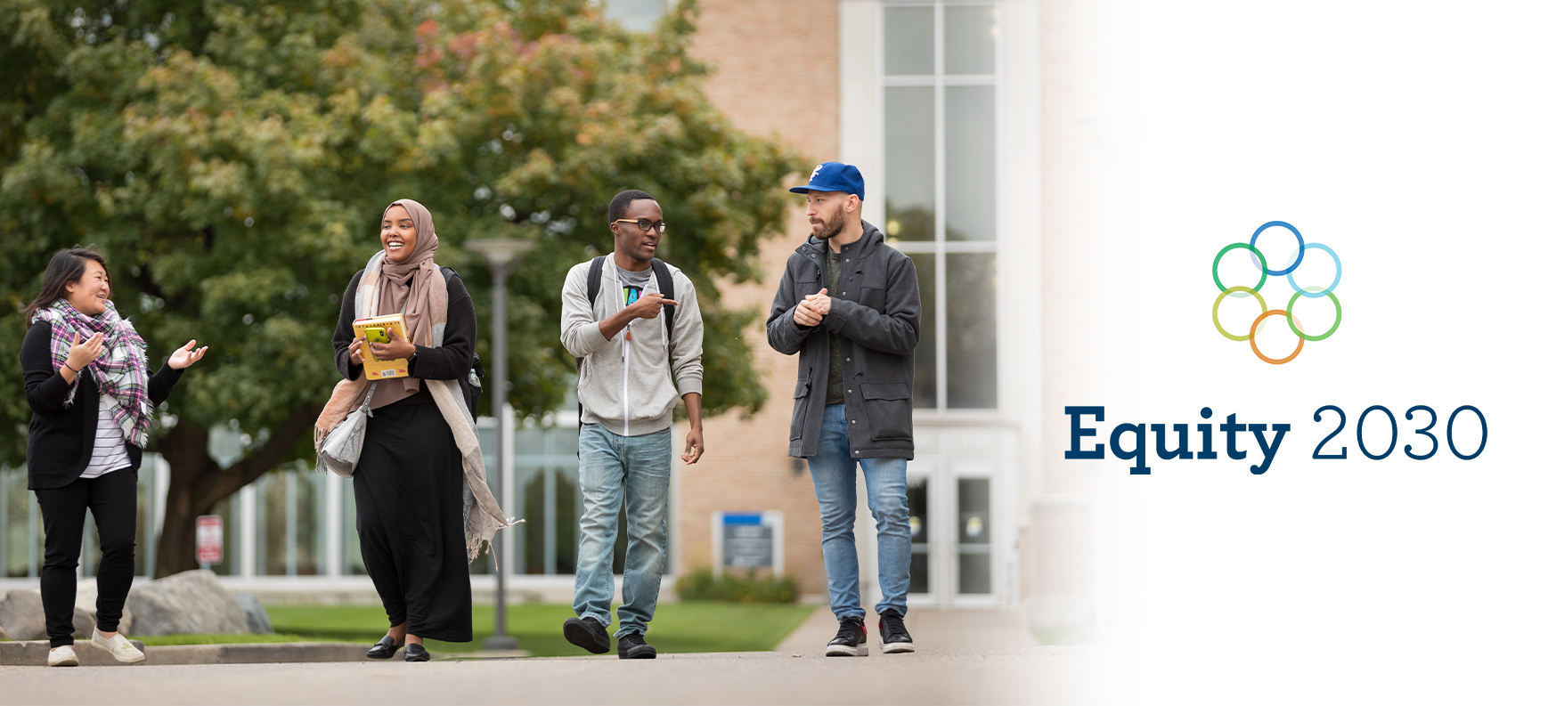 Four students walking together outside on campus